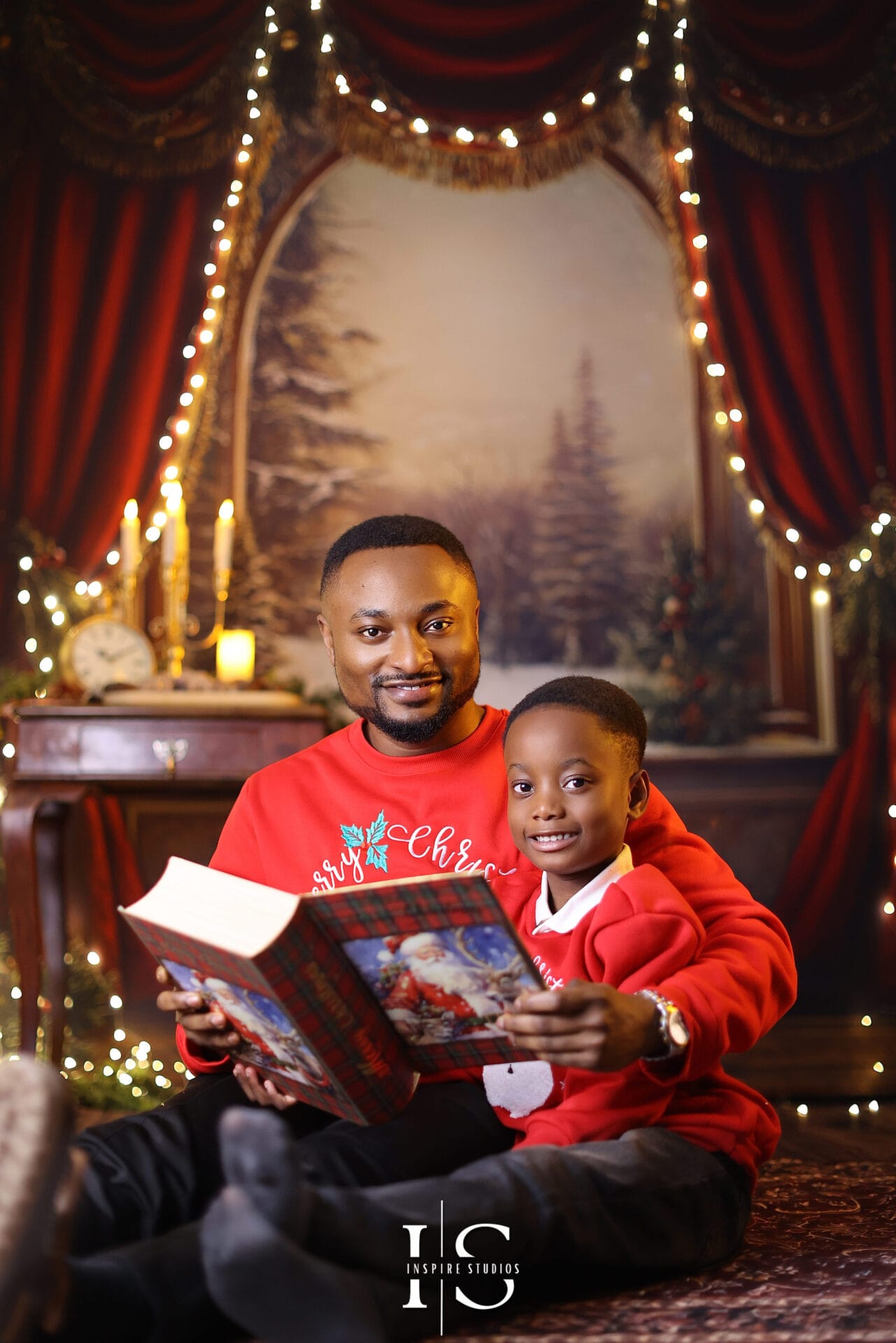 Indoor Christmas family portrait taken in a professional studio with elegant holiday decorations and warm lighting.