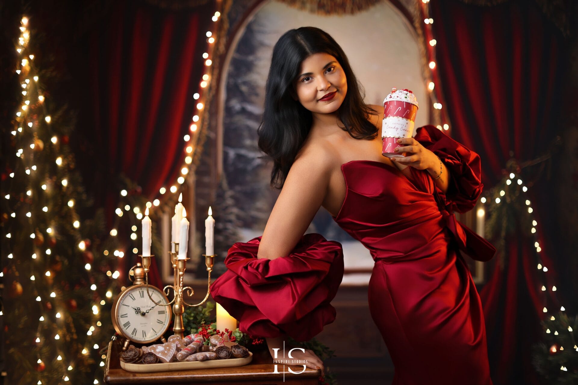 Woman posing in a luxury red Christmas setup in a London studio, suitable for all ages and families.