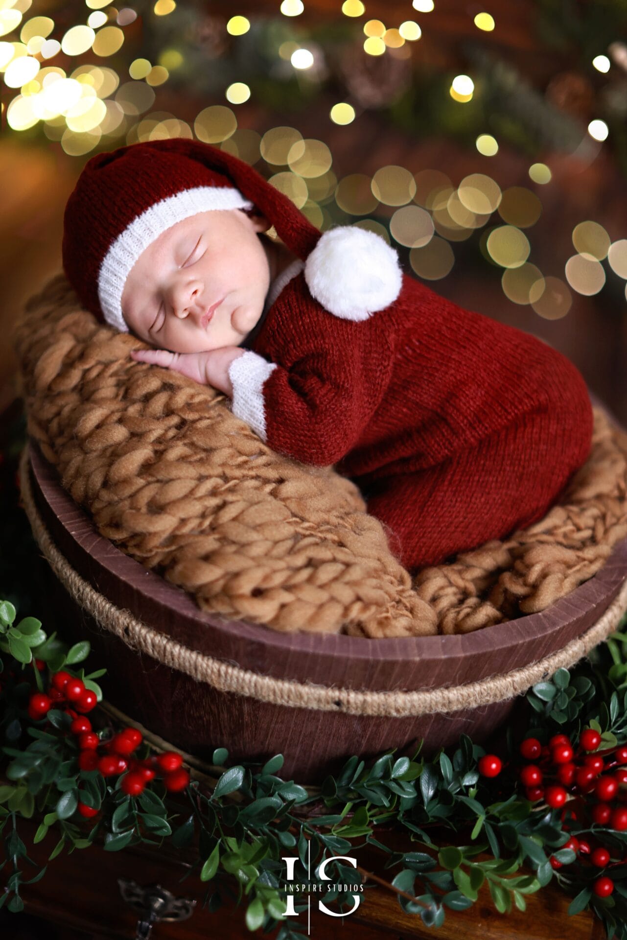 Newborn baby Christmas photoshoot in a London studio with festive outfits and cozy holiday setup.