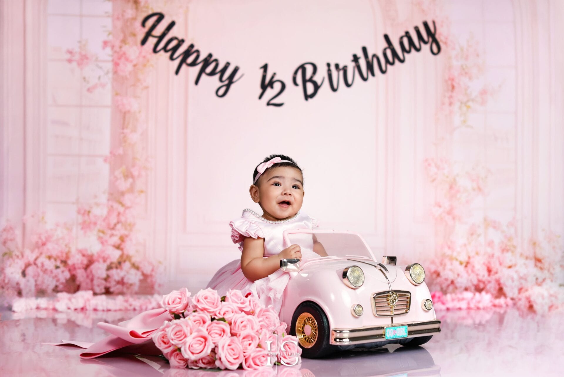 Six-month-old baby girl posing during a professional studio photoshoot with soft lighting and a neutral background