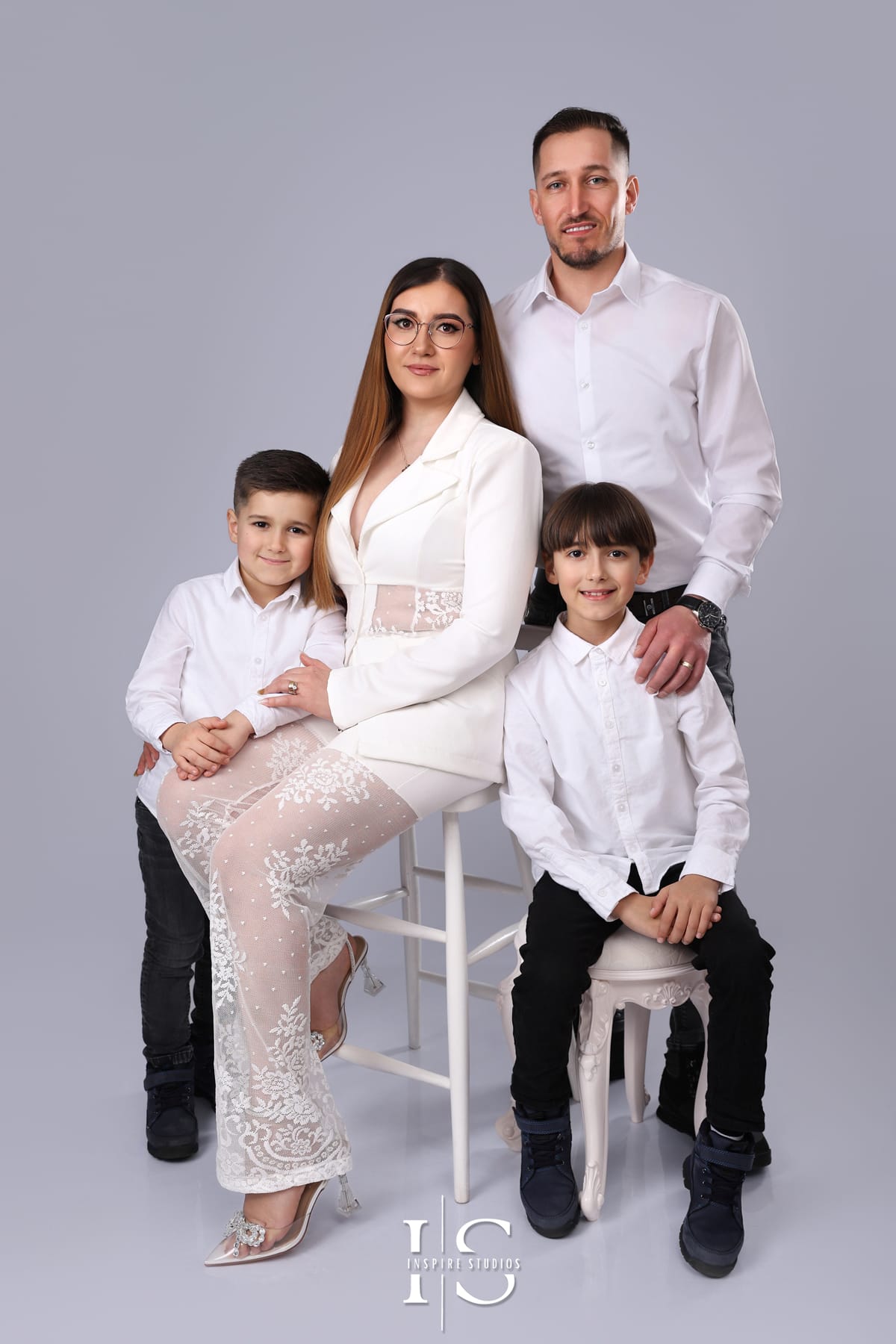 Family portrait photographed in a studio with a light grey backdrop during a professional family photography session.