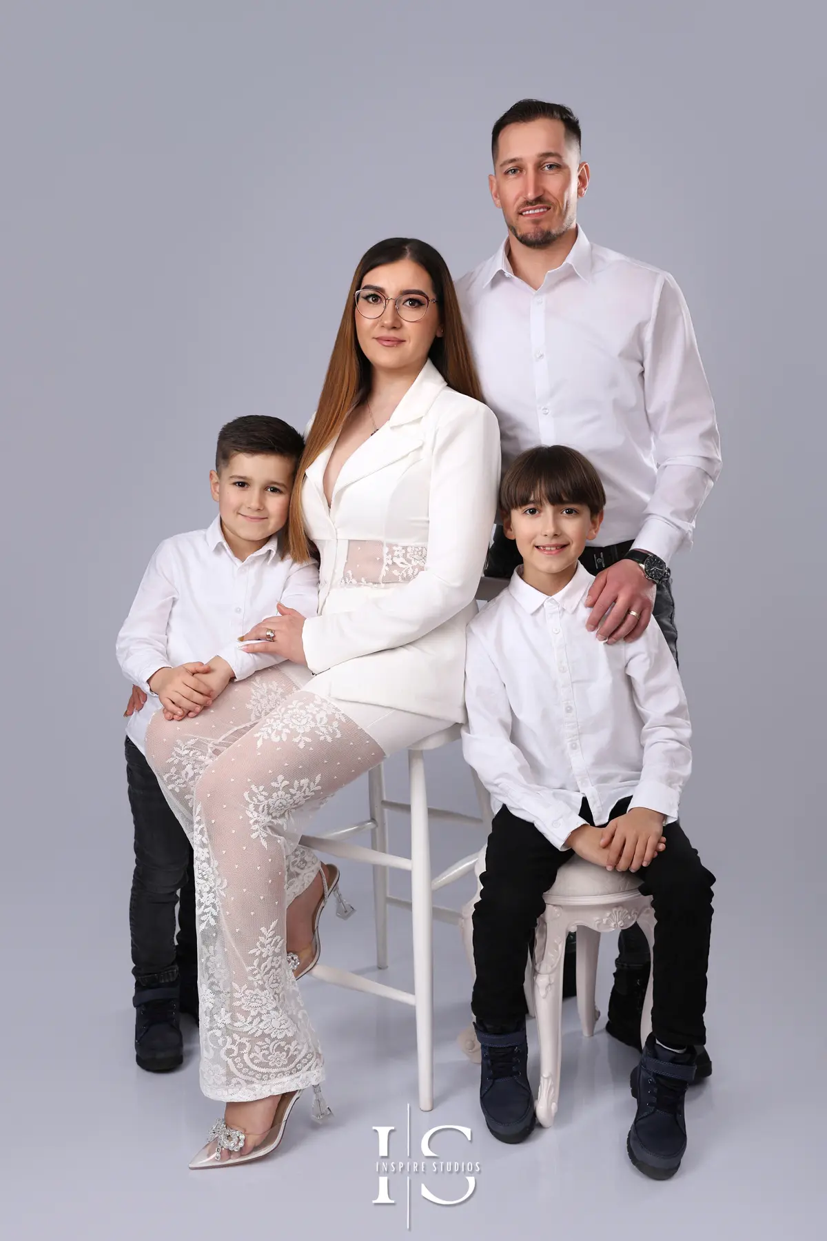 Family portrait photographed in a studio with a light grey backdrop during a professional family photography session.