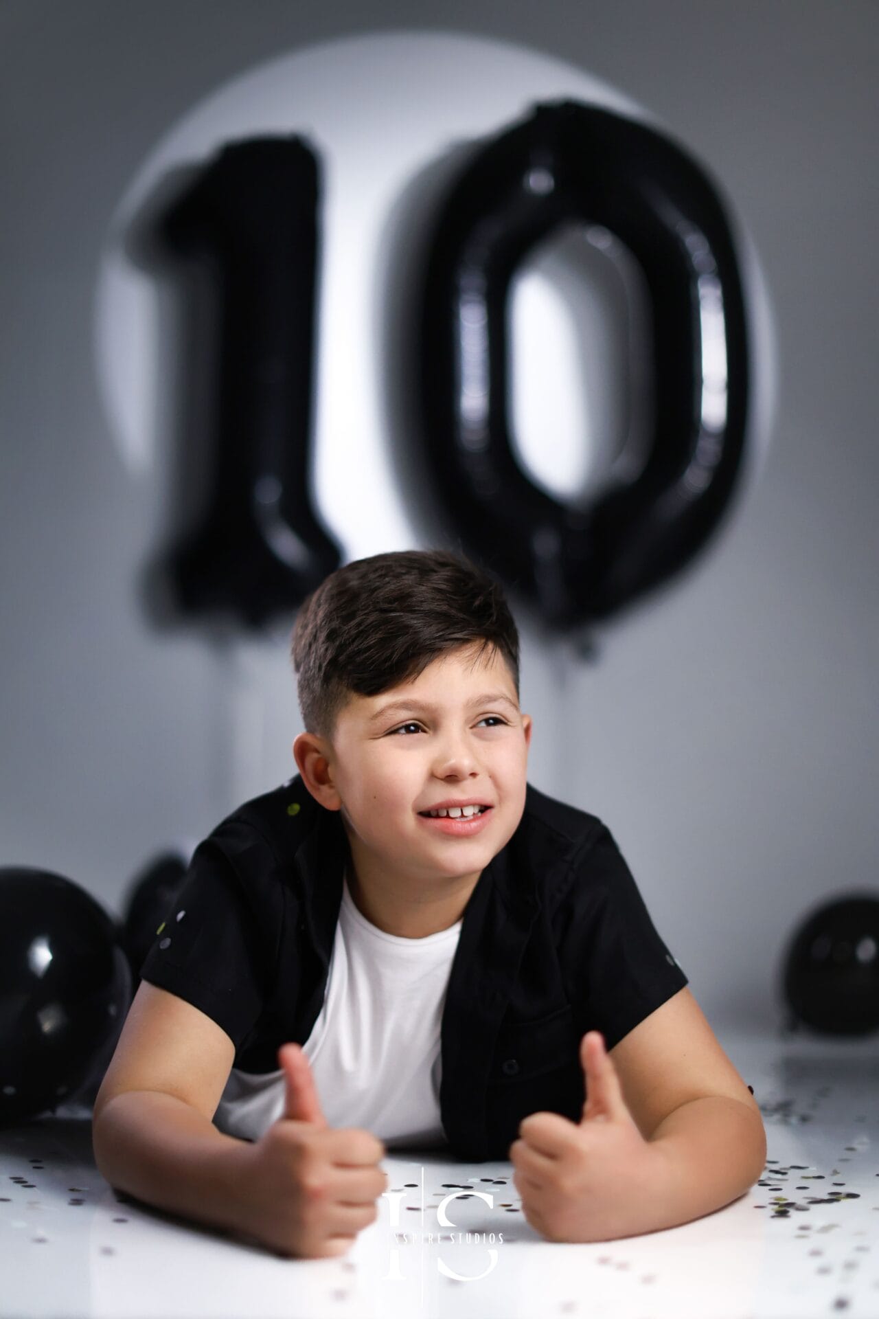 boy birthday photoshoot in London studio with modern setup and balloons