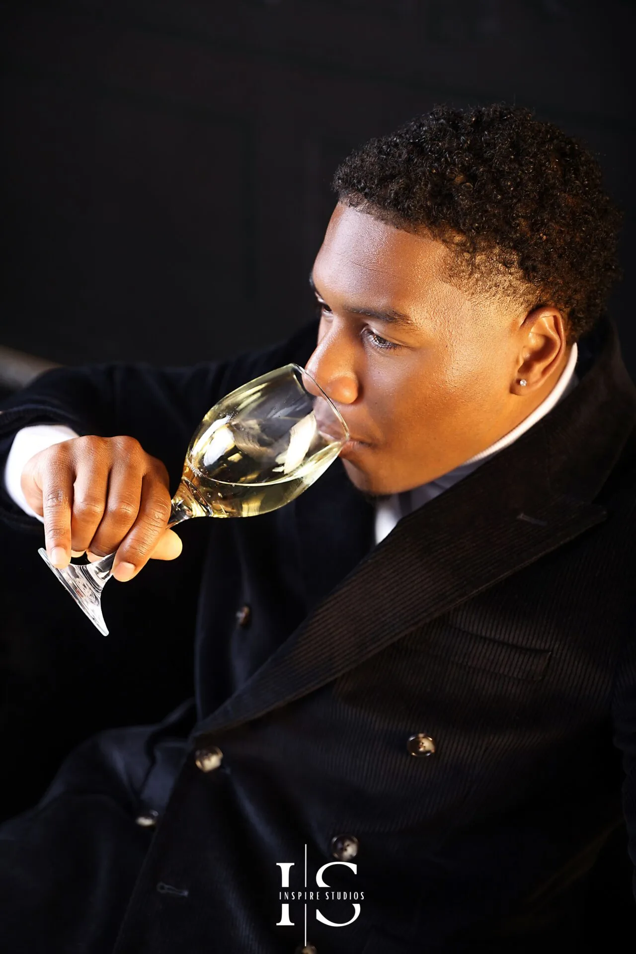 Stylish mens birthday photoshoot with dark background and champagne glass portrait