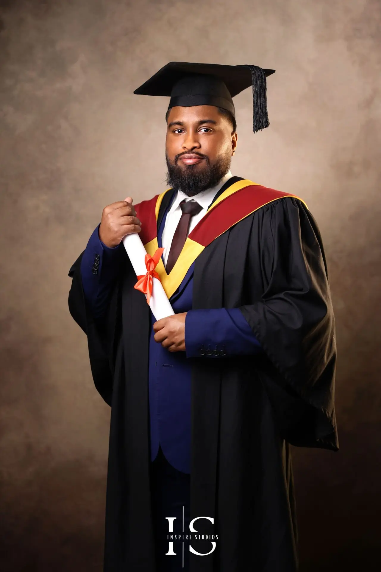 Fine art graduation studio portrait in London featuring a graduate in cap and gown with professional lighting.