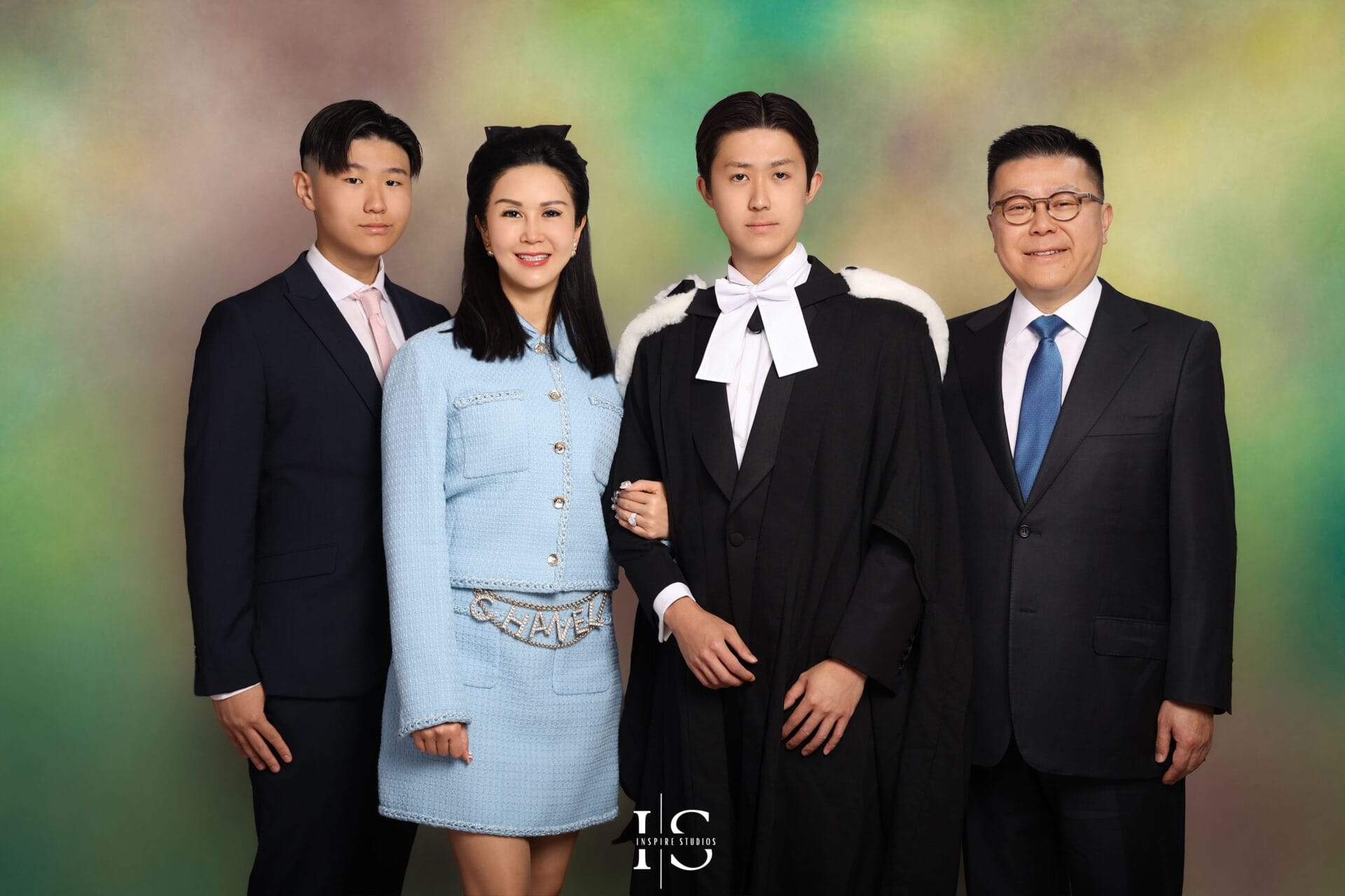 Korean fine art graduation studio portrait in London featuring graduate in formal robe with cinematic lighting and painterly vintage backdrop.