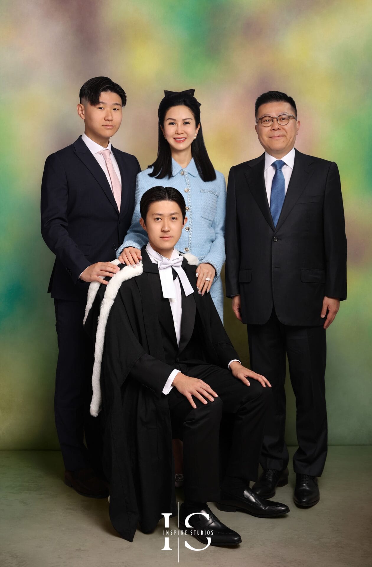 Korean graduation photoshoot in London with graduate wearing academic gown in luxury fine art studio portrait setting.