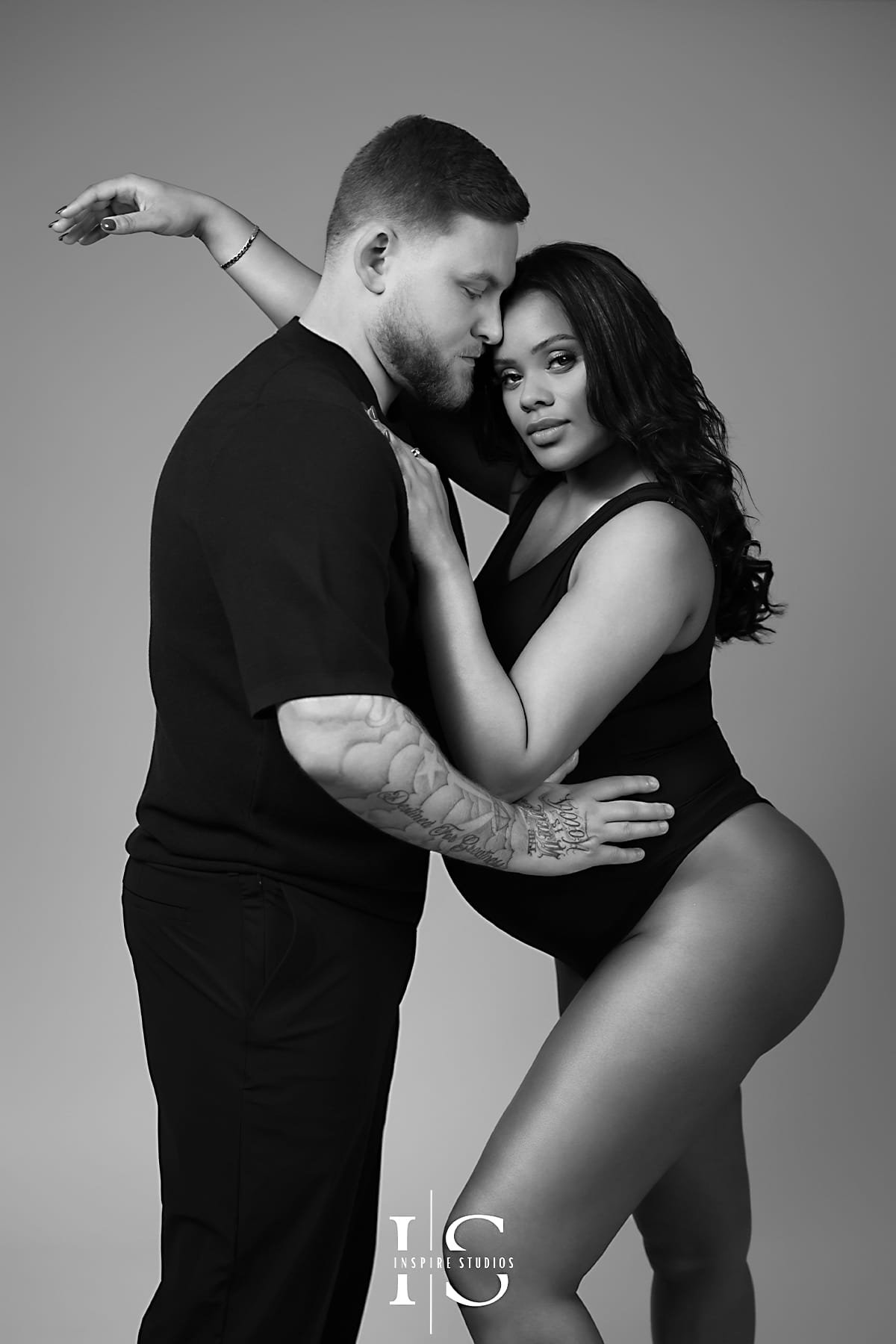 Creative maternity photoshoot in London with ultrasound background and artistic baby bump pose.