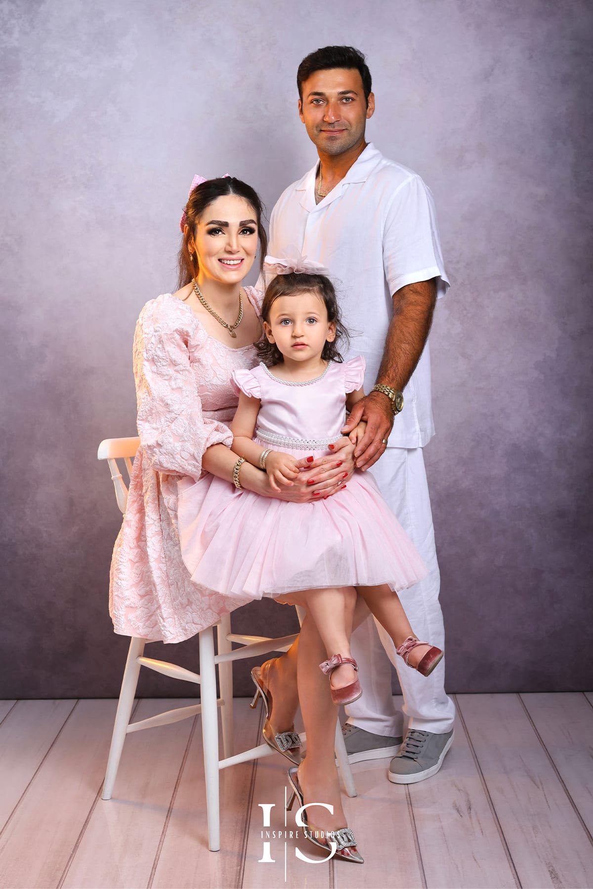 Family photography session at Inspire Studios with parents and children posing together in a warm, professional studio setting.
