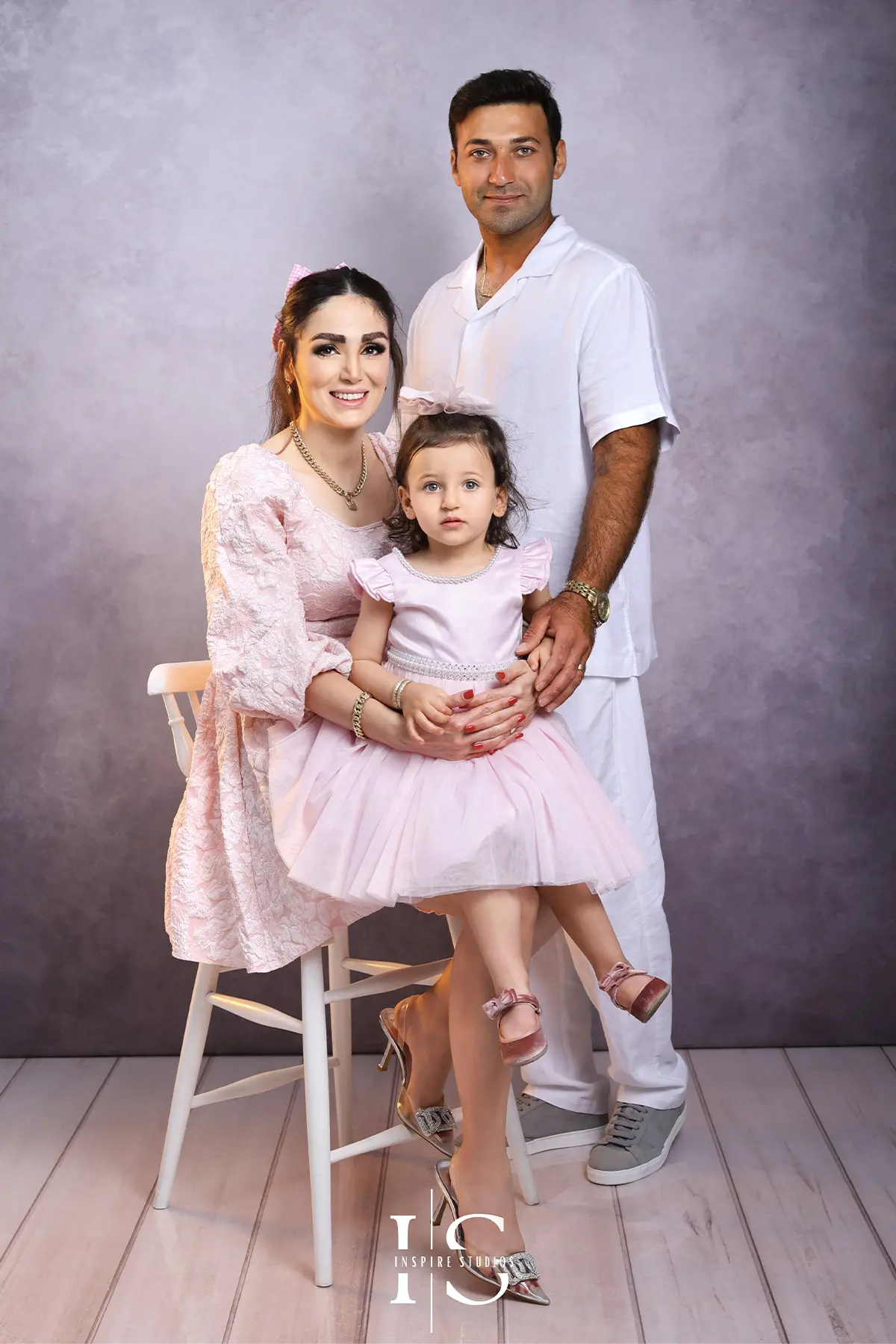 Family photography session at Inspire Studios with parents and children posing together in a warm, professional studio setting.
