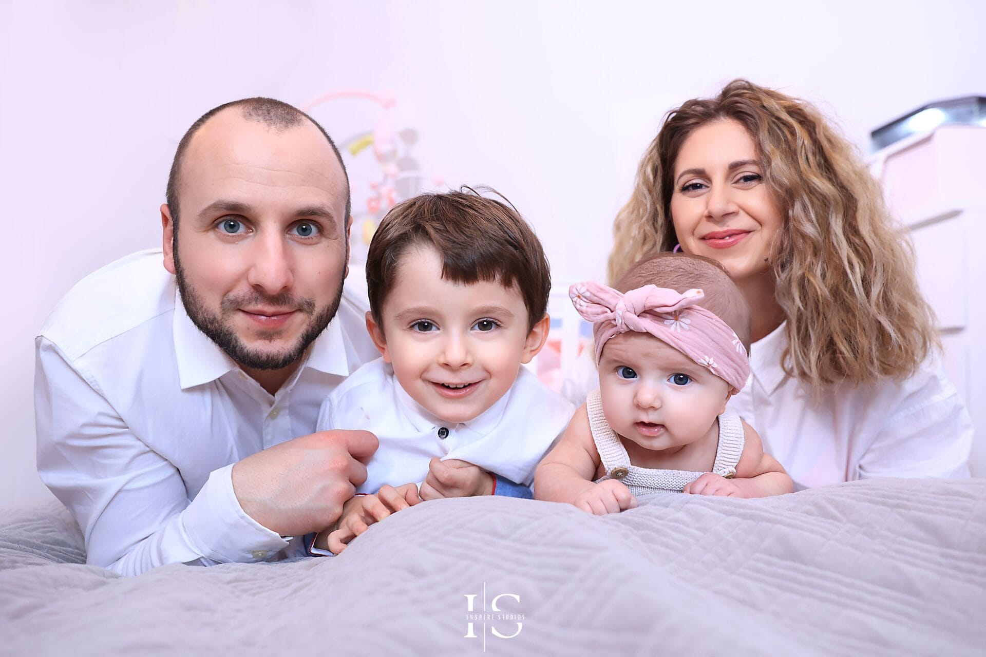 Părinți și bebeluș fotografiați acasă în Londra înainte de botez.