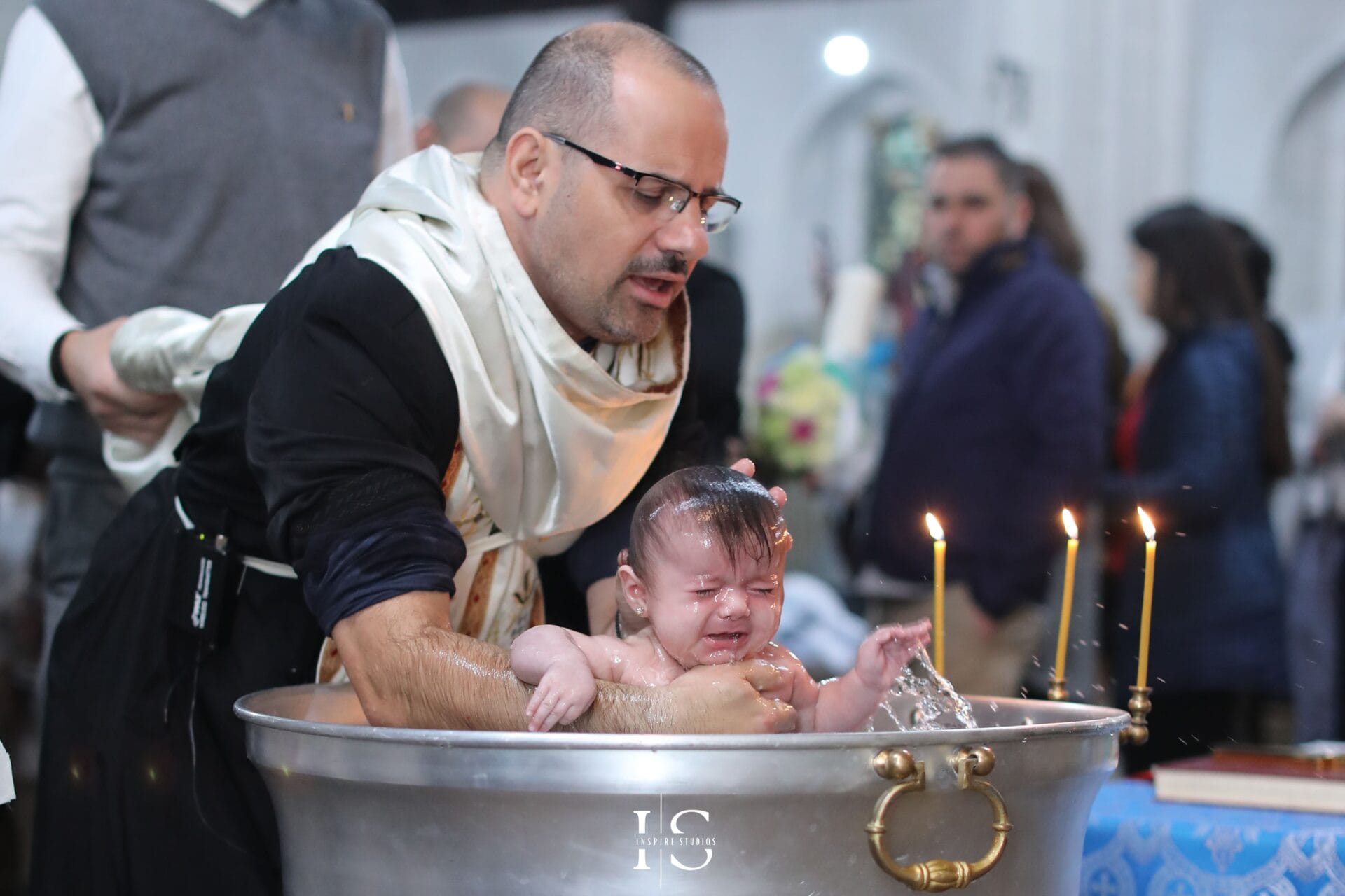 Baptism photography at St Margaret and St Columba Church in London with baby, parents and family during the ceremony.