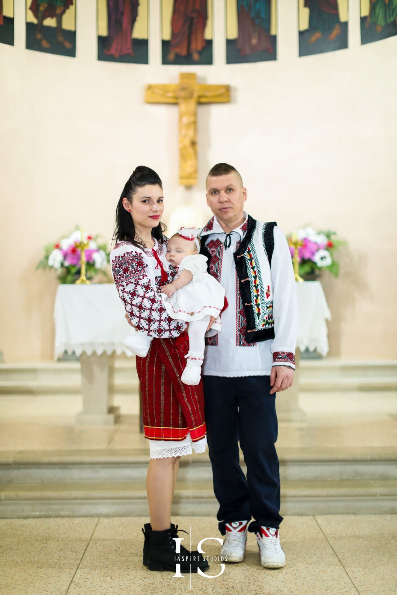Romanian christening at St Sebastian and Pancras Church in London with baby and family during the ceremony.