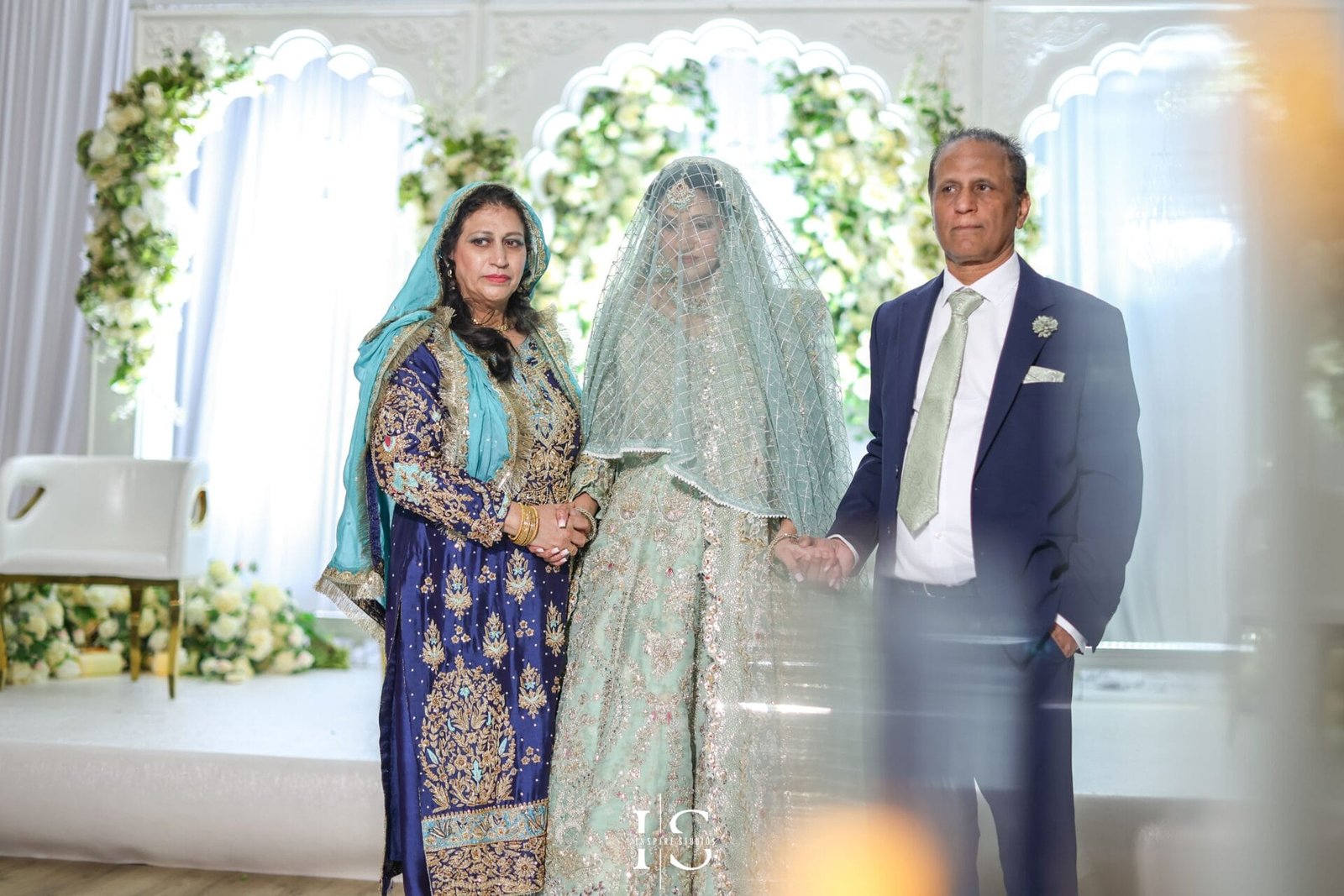 Bride posing with her parents at Hylands House wedding venue in Essex.