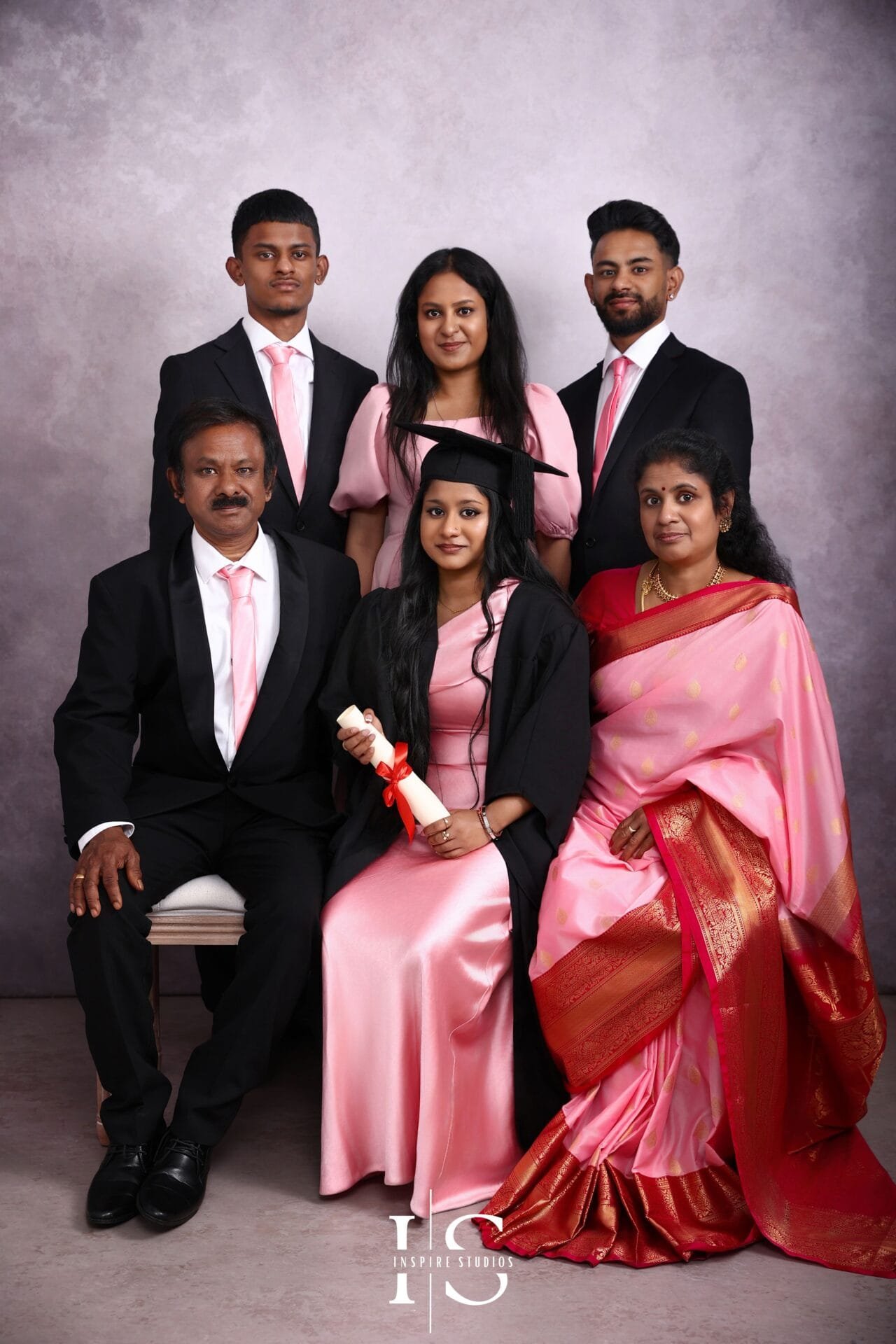 Family graduation photoshoot at an East London studio with a graduate and relatives posing together for professional graduation portraits.