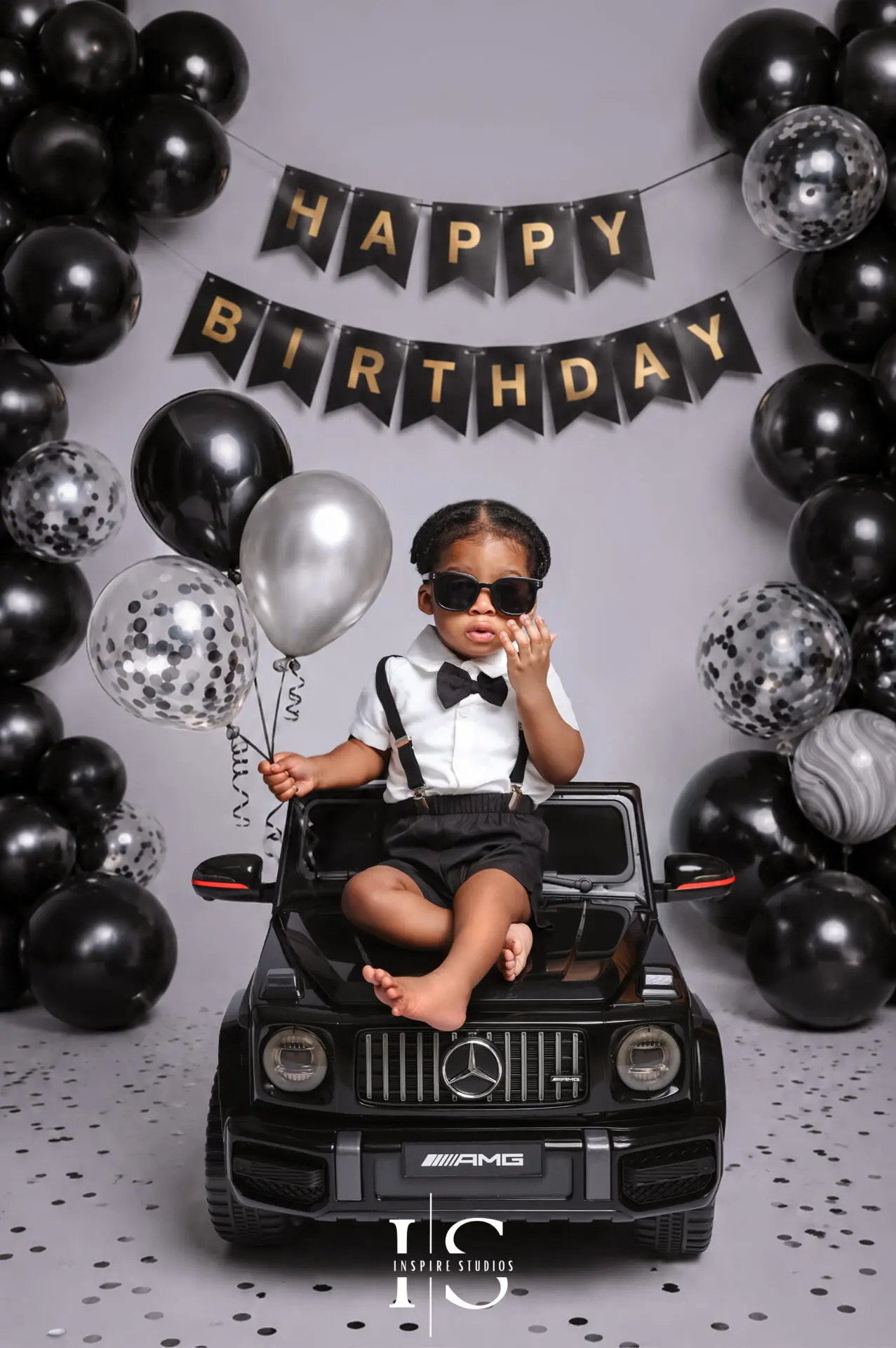 First birthday photoshoot with baby girl sitting in a convertible car studio setup in London.