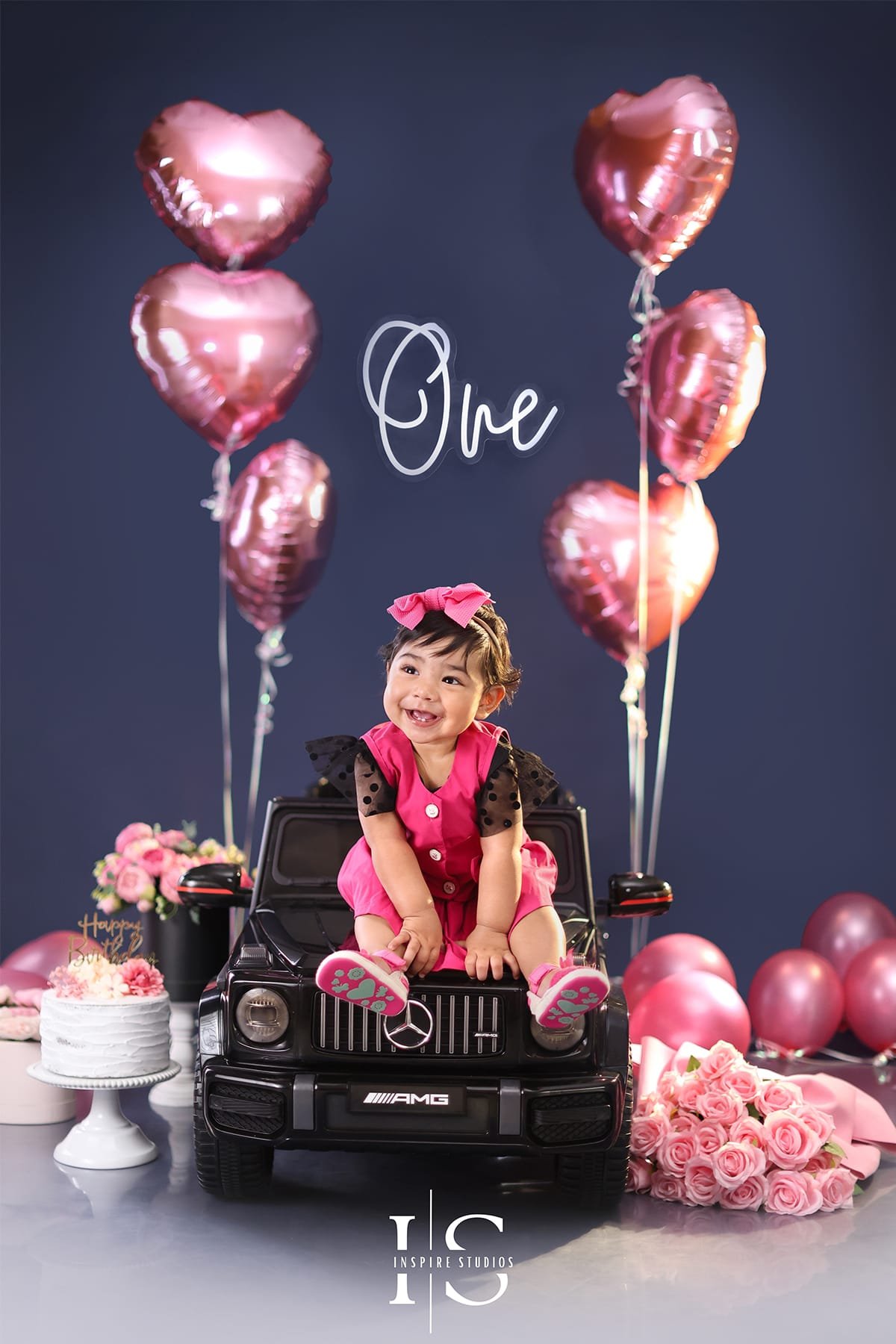 Baby posing in a convertible car setup during a first birthday photoshoot in London