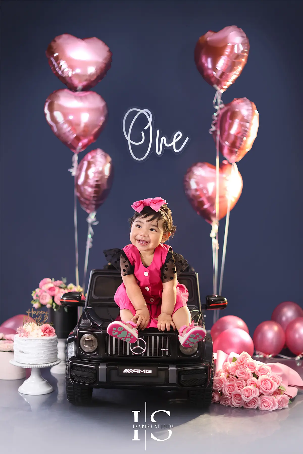 Baby posing in a convertible car setup during a first birthday photoshoot in London