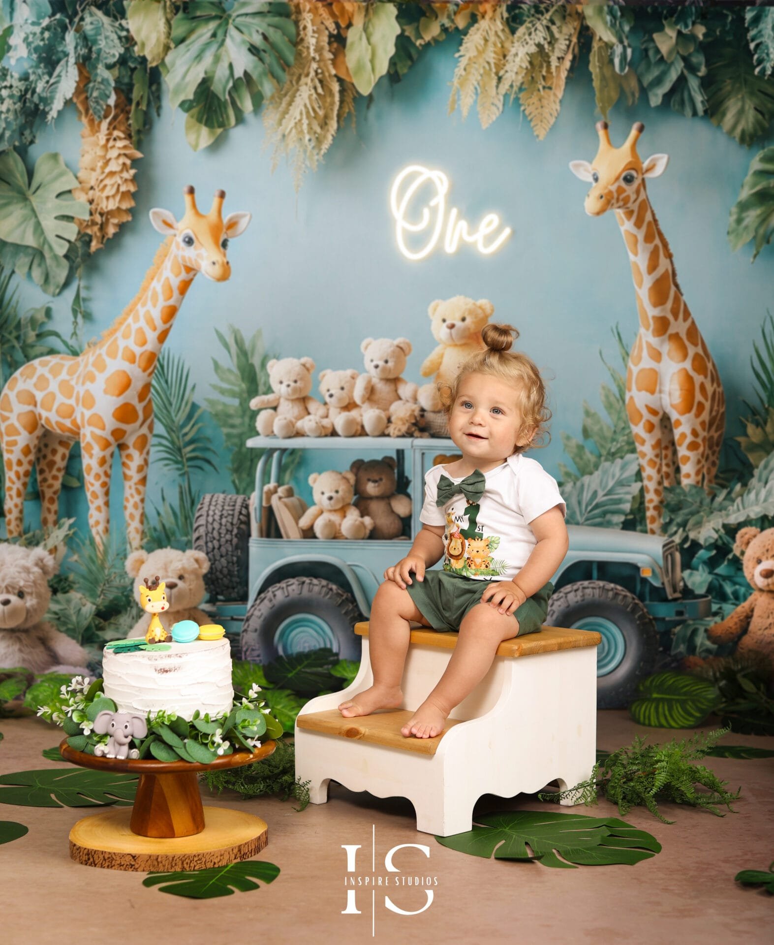 Baby celebrating a first birthday photoshoot with a jungle-themed backdrop in a London photography studio