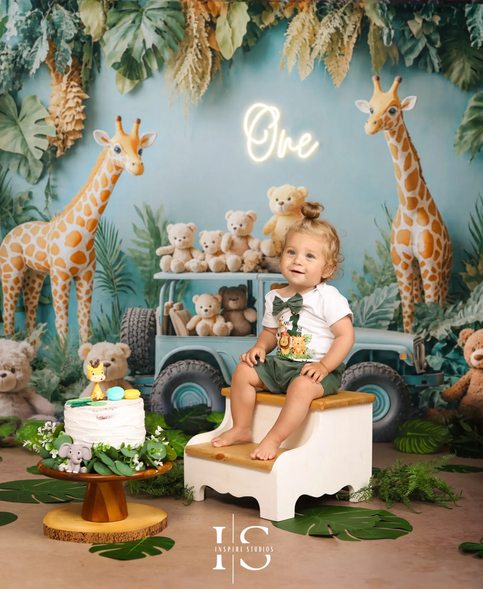 Baby celebrating a first birthday photoshoot with a jungle-themed backdrop in a London photography studio