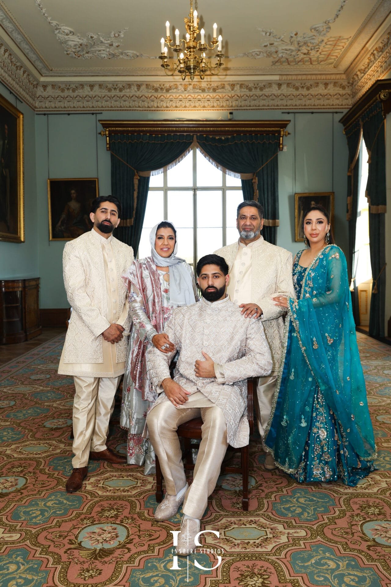 Groom posing with family members inside Hylands House, Chelmsford.
