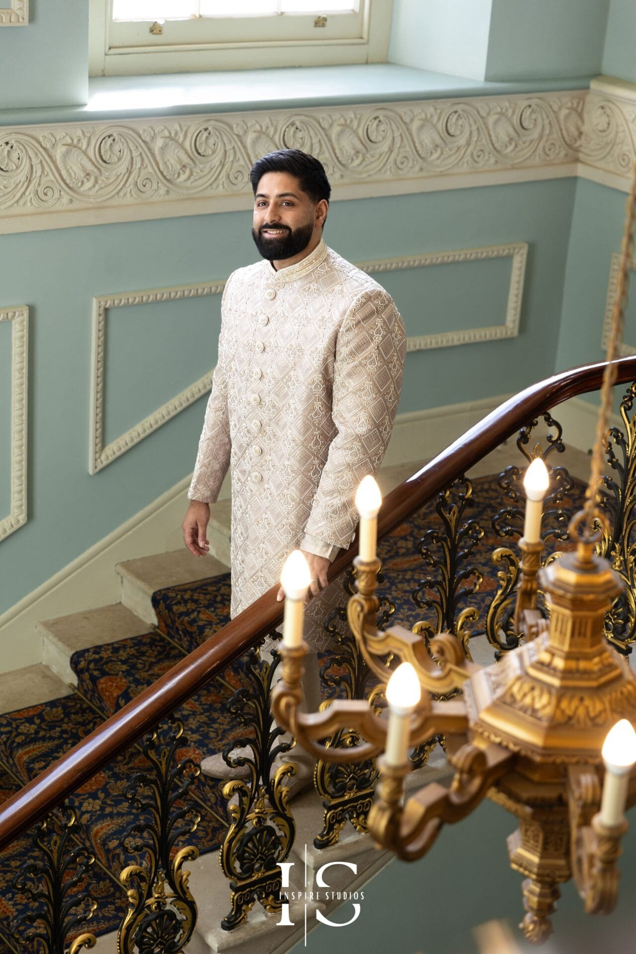 Groom posing on the Grand Staircase at Hylands House in Chelmsford.