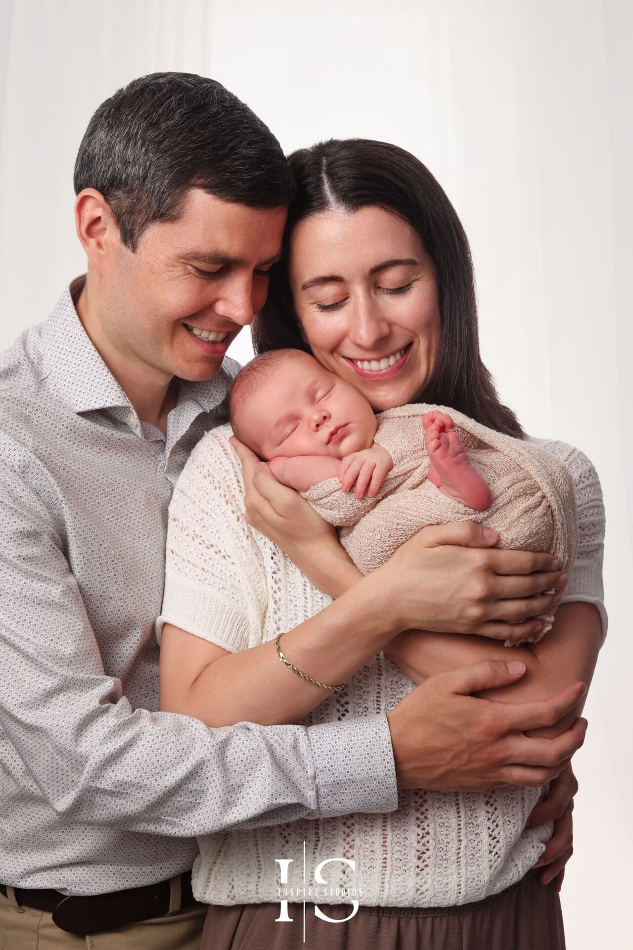 Newborn family photoshoot at Inspire Studios London with baby, parents and sibling in a studio portrait.