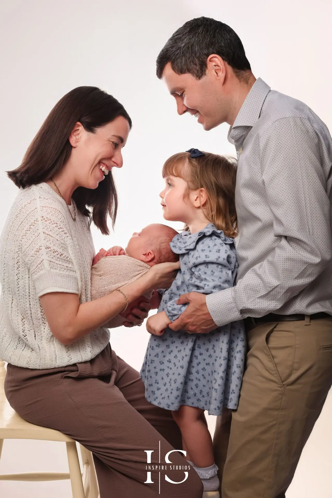 Newborn photoshoot with sister and parents in London, featuring a baby boy with his family in a studio portrait.