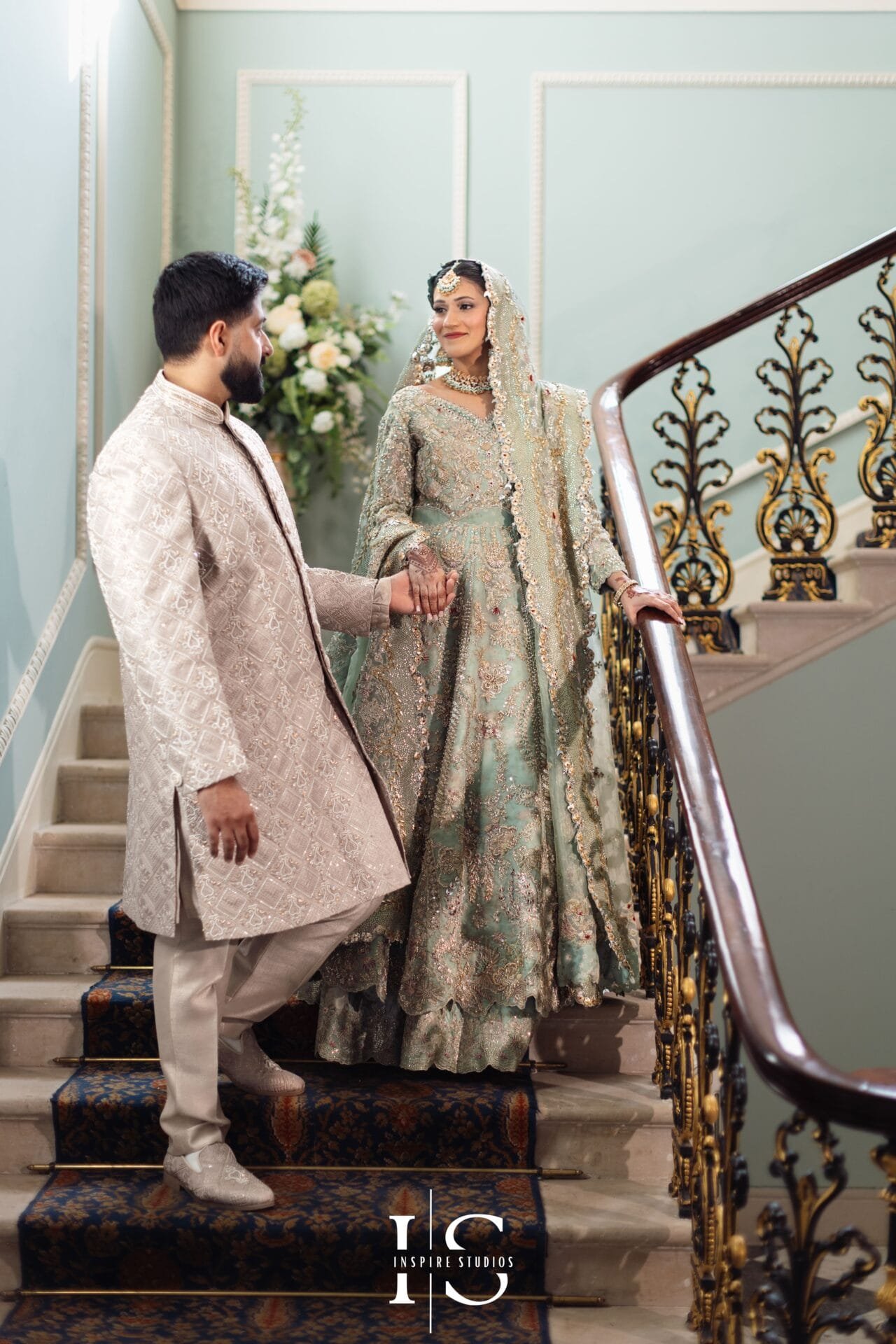 Pakistani bride and groom sharing their first look on the Hylands House Grand Staircase.