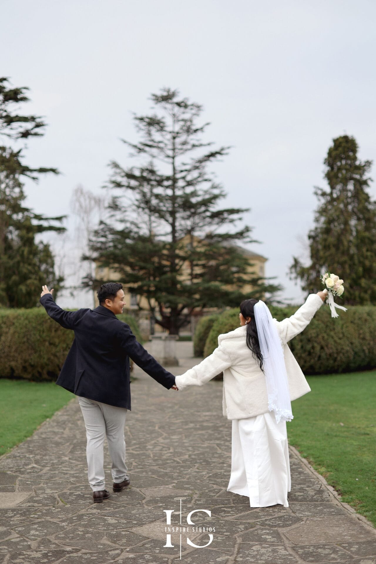 Filipino bride and groom walking together during their outdoor wedding portrait session in Danson Park, Bexley.