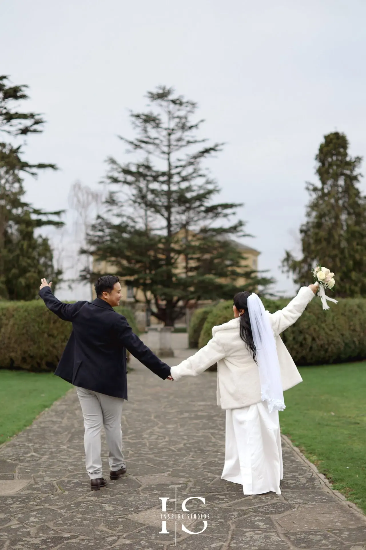 Filipino bride and groom walking together during their outdoor wedding portrait session in Danson Park, Bexley.