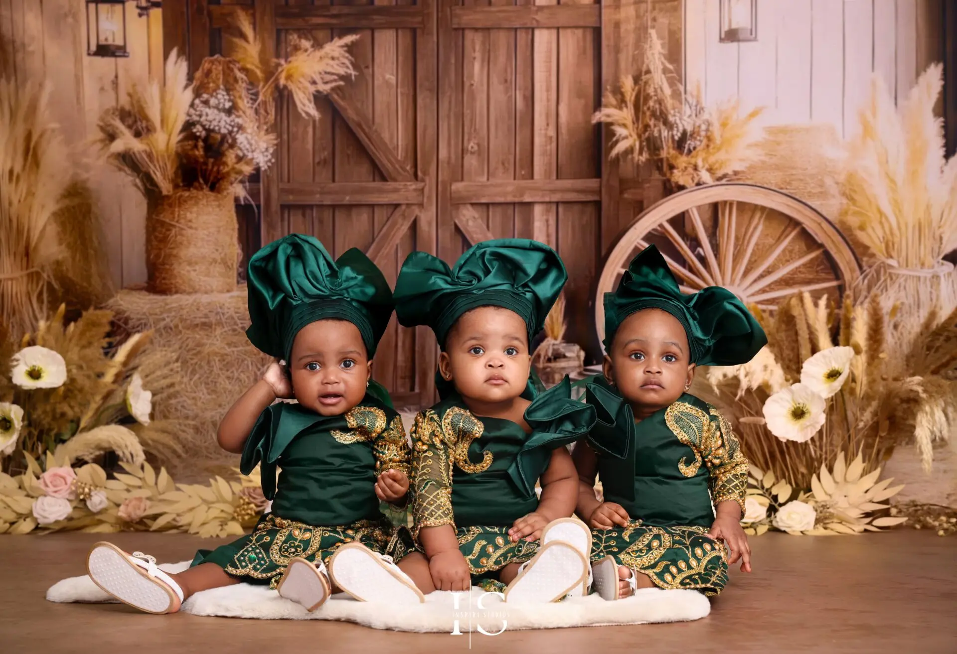 One-year-old triplets wearing traditional African outfits during a boho birthday photoshoot in London.